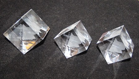 Tre fyrkantiga kristallblock ståendes på högkant som vardera utgör ett pris för Årets Russian Blue.
